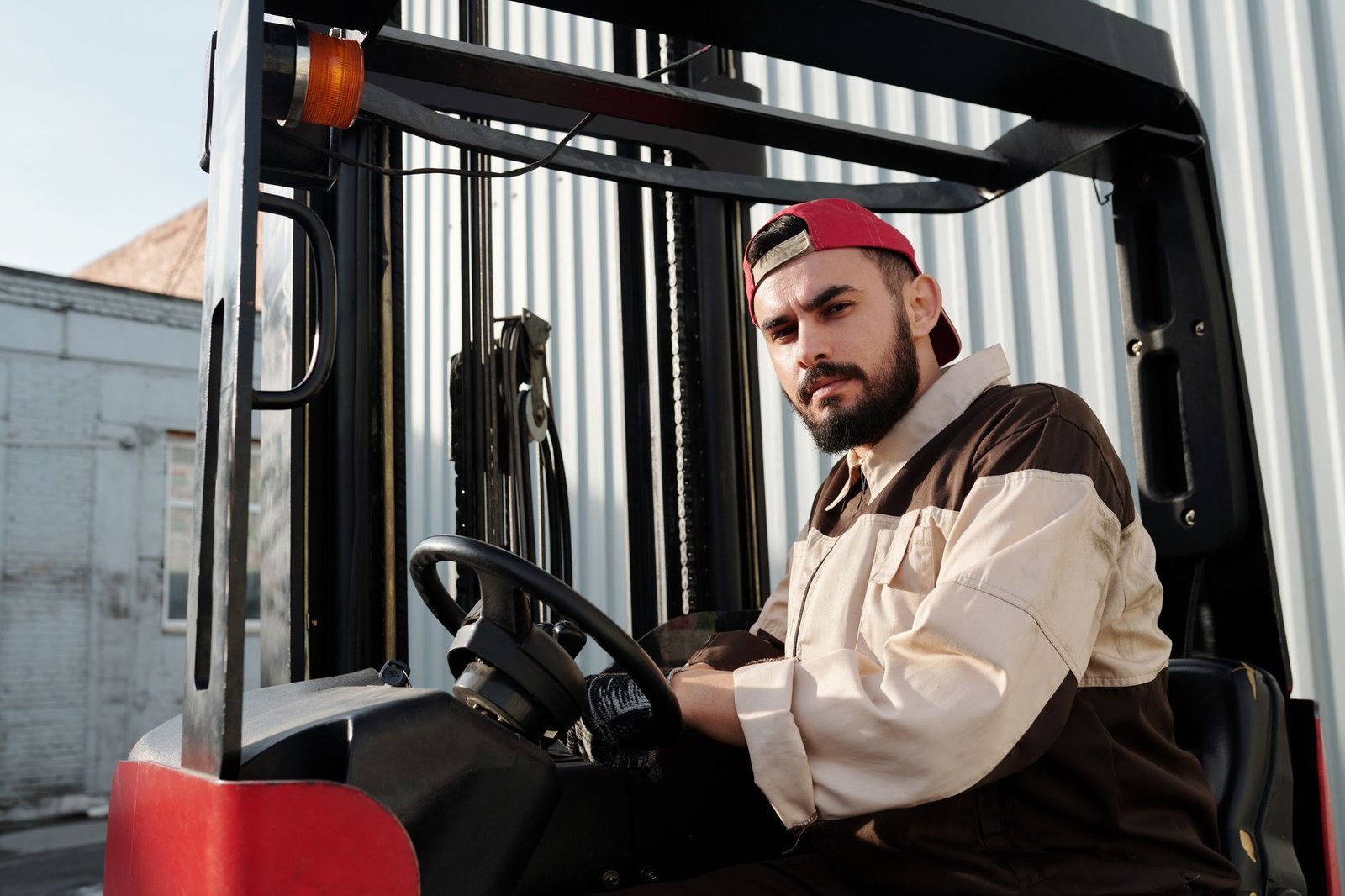 Depoda baret takan operatörün forklifti güvenle sürmesi